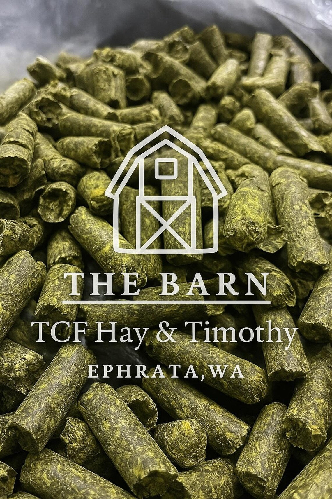 Close-up of green alfalfa pellets with The Barn TCF Hay & Timothy logo and Ephrata, WA text