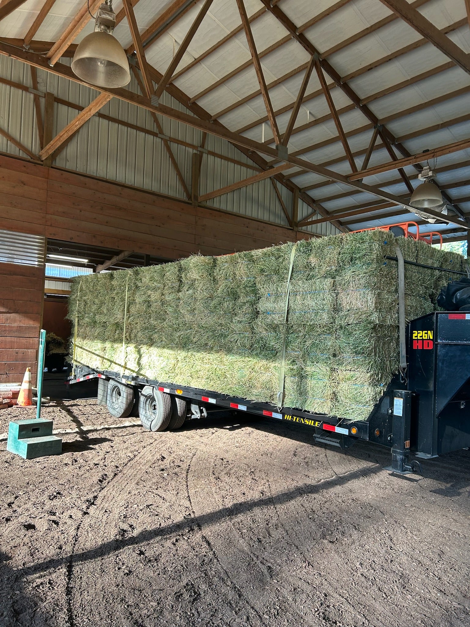 Trailer with Timothy hay bales inside a barn